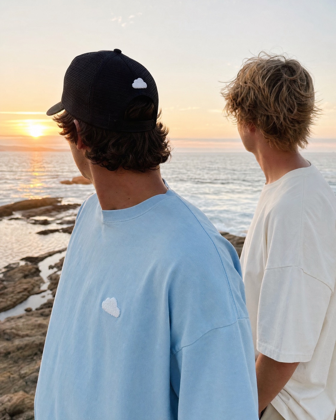 Two friends at the beach wearing the Puff Tee and the Cloud Cap